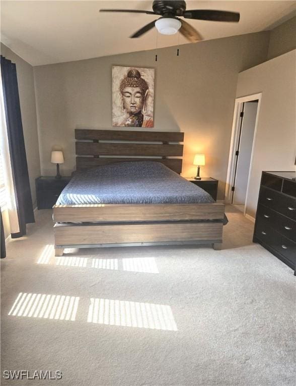 unfurnished bedroom featuring ceiling fan, light colored carpet, and vaulted ceiling