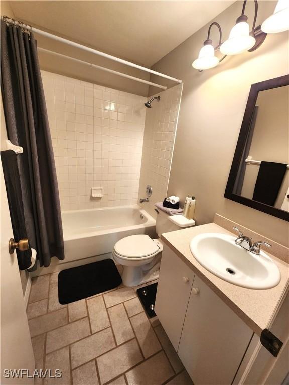 full bathroom featuring toilet, shower / bathtub combination with curtain, and vanity