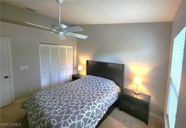 bedroom with a closet, ceiling fan, carpet, and vaulted ceiling