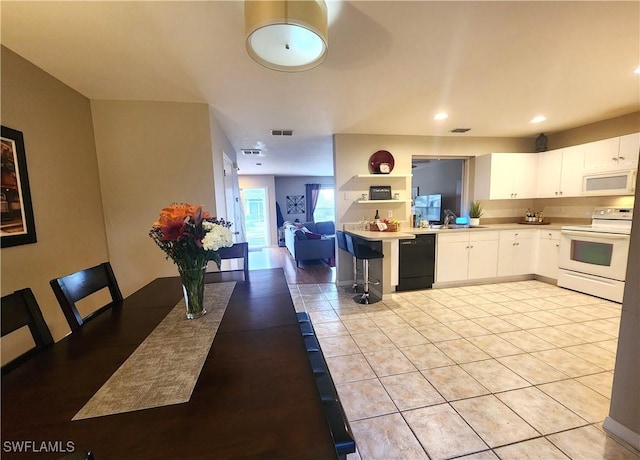 kitchen featuring sink, light tile patterned flooring, white appliances, and white cabinets