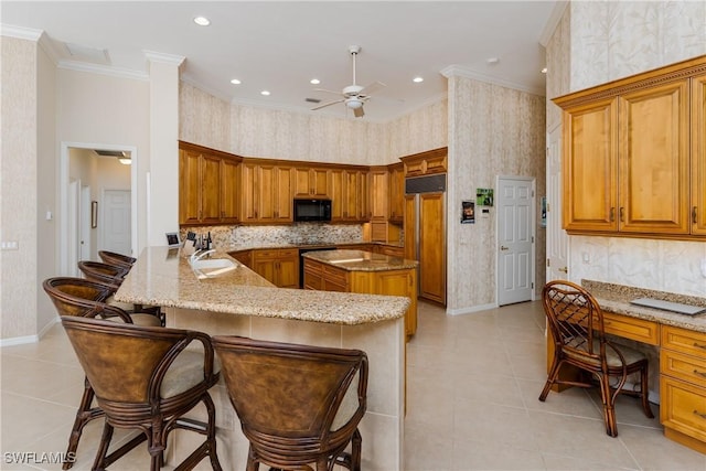 kitchen with ceiling fan, sink, a kitchen breakfast bar, kitchen peninsula, and crown molding