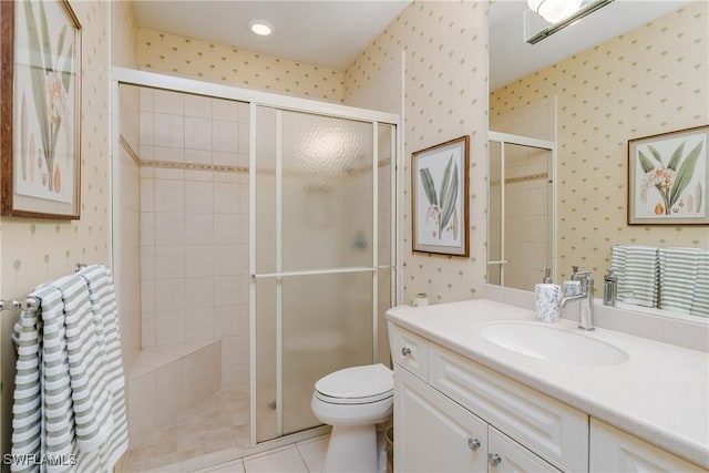 bathroom with tile patterned flooring, vanity, toilet, and a shower with shower door