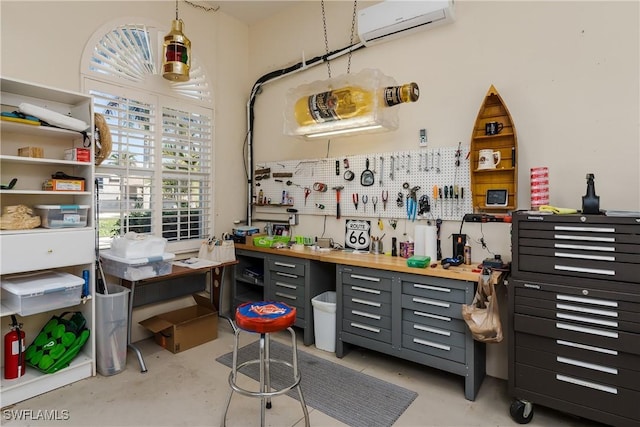 miscellaneous room featuring a workshop area and a wall mounted AC