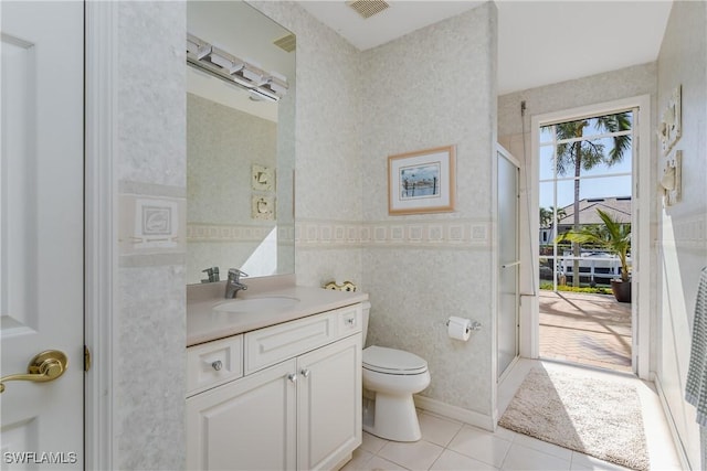 bathroom with toilet, vanity, and tile patterned floors