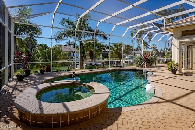 view of pool featuring a lanai, an in ground hot tub, and a patio