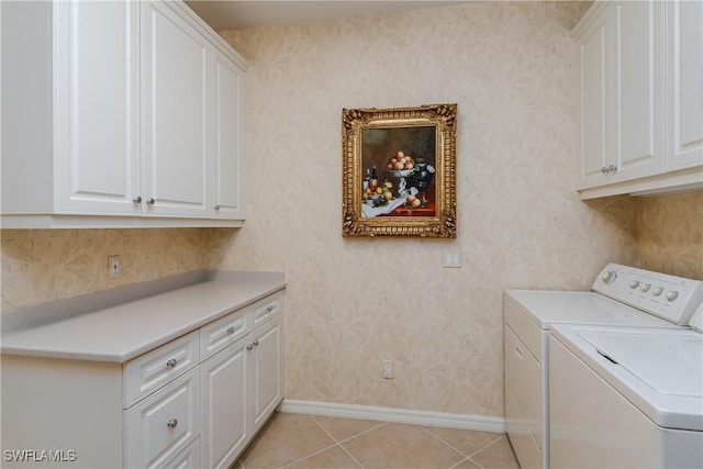 laundry room with washer and clothes dryer, light tile patterned flooring, and cabinets