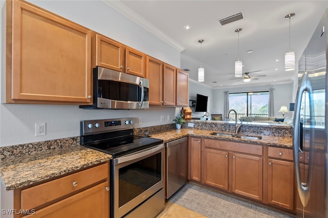 kitchen featuring sink, hanging light fixtures, ceiling fan, ornamental molding, and stainless steel appliances