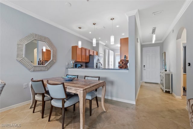 dining space featuring light tile patterned flooring and ornamental molding