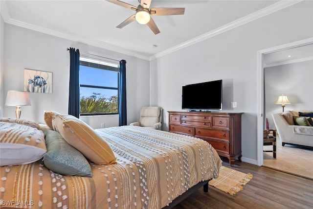 bedroom featuring ceiling fan, wood-type flooring, and crown molding