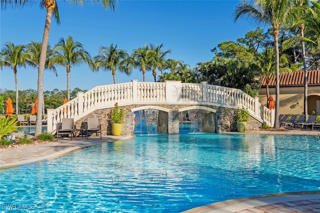 view of swimming pool with pool water feature