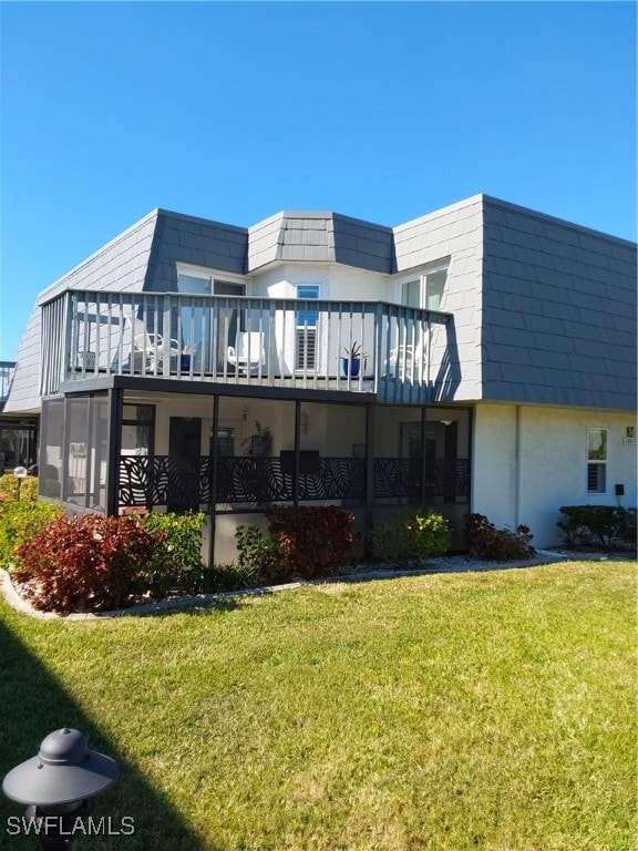 rear view of house featuring a yard and a wooden deck