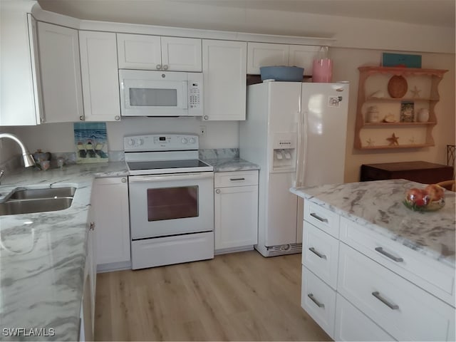 kitchen featuring white appliances, white cabinets, sink, light hardwood / wood-style flooring, and light stone counters