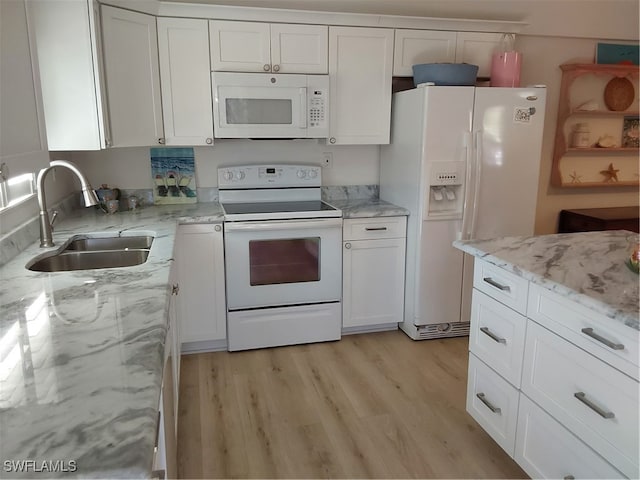 kitchen featuring light stone countertops, light wood-type flooring, white appliances, sink, and white cabinets