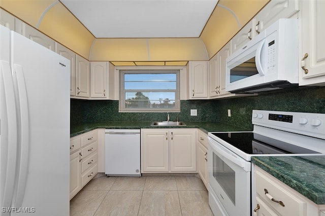 kitchen featuring light tile patterned floors, white appliances, sink, white cabinetry, and backsplash