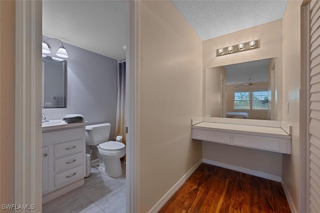 bathroom featuring hardwood / wood-style flooring, vanity, a textured ceiling, and toilet