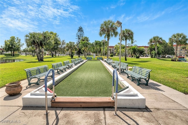 view of community with a yard and a water view