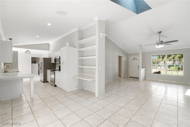 interior space with vaulted ceiling with skylight, crown molding, built in shelves, a sink, and light tile patterned flooring