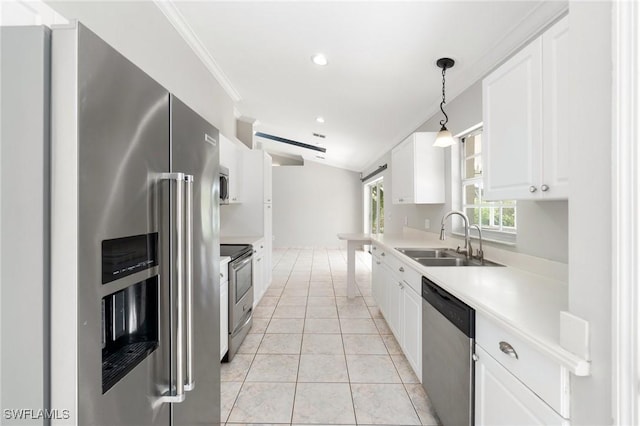 kitchen featuring a sink, white cabinets, light countertops, appliances with stainless steel finishes, and hanging light fixtures