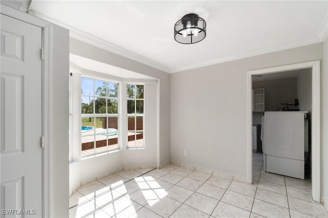 unfurnished dining area with ornamental molding, washer / clothes dryer, and light tile patterned floors