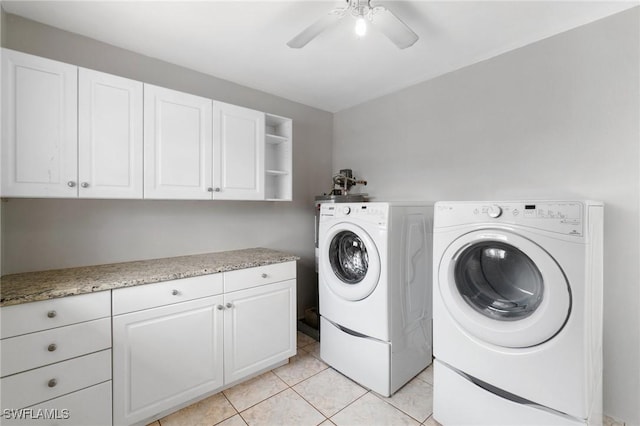 washroom featuring light tile patterned floors, washing machine and clothes dryer, cabinet space, and a ceiling fan