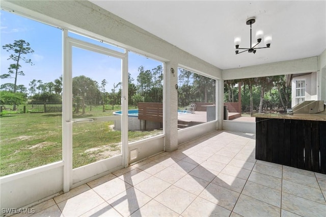 unfurnished sunroom featuring a notable chandelier