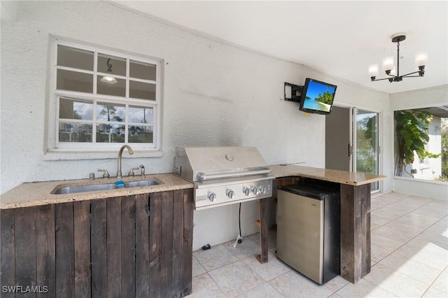 view of patio with exterior kitchen, a sink, and a grill