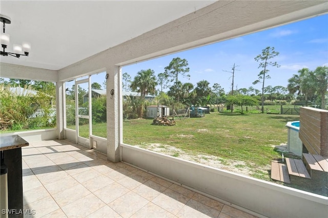 unfurnished sunroom featuring a chandelier