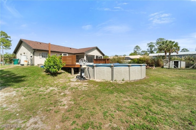 view of yard featuring a deck and an outdoor pool