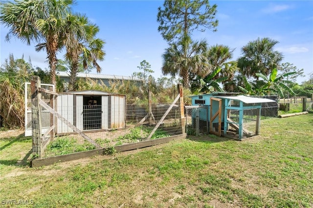 view of playground with a vegetable garden, exterior structure, an outbuilding, and a yard