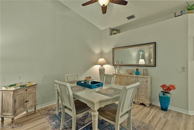 dining area with ceiling fan, vaulted ceiling, and light wood-type flooring