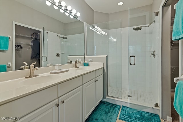 bathroom with vanity and a shower with door