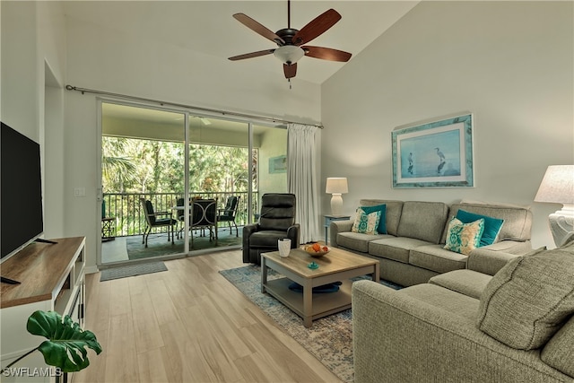 living room featuring light hardwood / wood-style floors, high vaulted ceiling, and ceiling fan