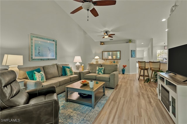 living room with light wood-type flooring and vaulted ceiling