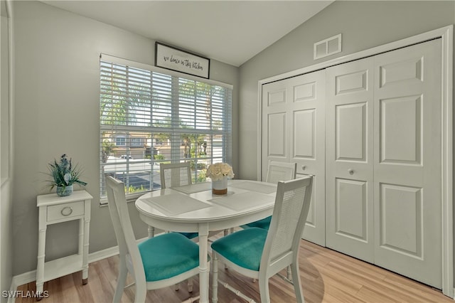 dining space with lofted ceiling and light hardwood / wood-style flooring