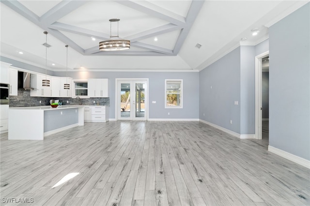 unfurnished living room with beam ceiling, light hardwood / wood-style flooring, and sink