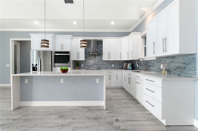 kitchen with a kitchen island, stainless steel appliances, white cabinetry, and hanging light fixtures