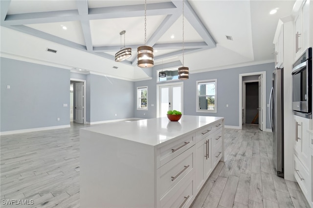 kitchen with stainless steel appliances, a center island, french doors, white cabinetry, and decorative light fixtures