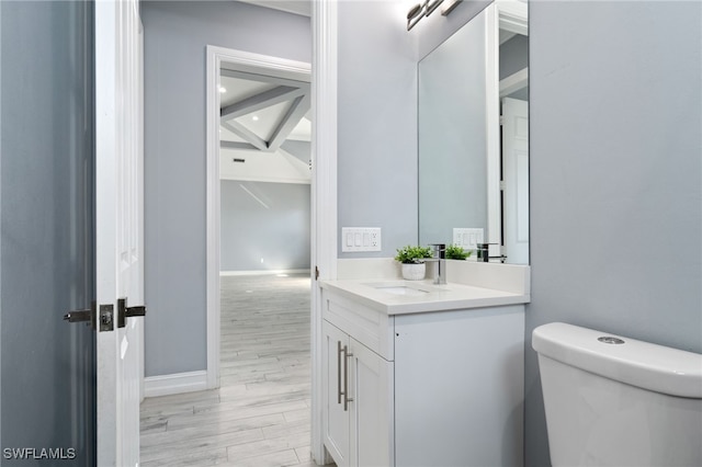 bathroom featuring toilet, vanity, and hardwood / wood-style flooring