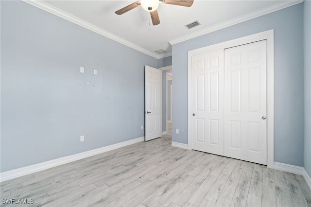 unfurnished bedroom featuring ceiling fan, light wood-type flooring, a closet, and crown molding