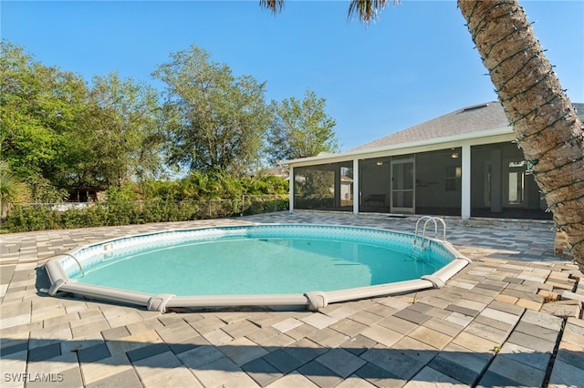 view of pool with a patio and a sunroom