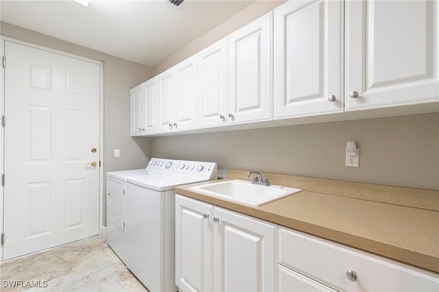 laundry area with cabinets, independent washer and dryer, and sink