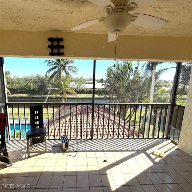 balcony with ceiling fan and a water view