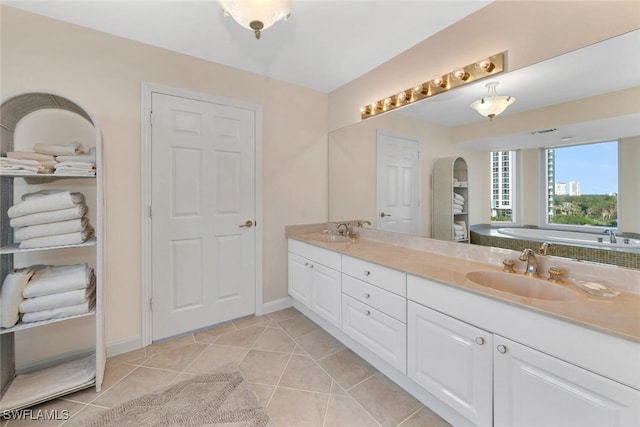 bathroom featuring tile patterned flooring, vanity, and a bath