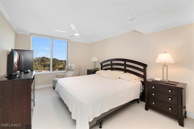 carpeted bedroom featuring ceiling fan and ornamental molding