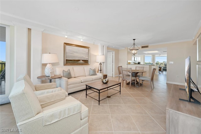 living room featuring an inviting chandelier, ornamental molding, and light tile patterned flooring