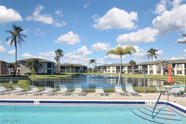 view of pool featuring a water view and a patio