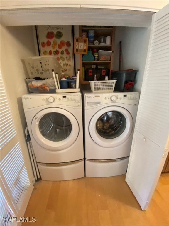 washroom with light hardwood / wood-style flooring and washing machine and clothes dryer