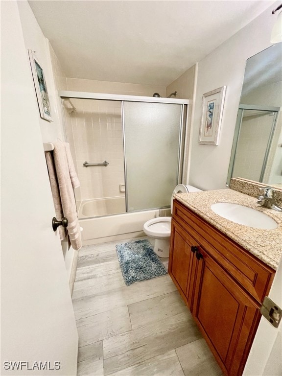 full bathroom with vanity, toilet, and shower / bath combination with glass door