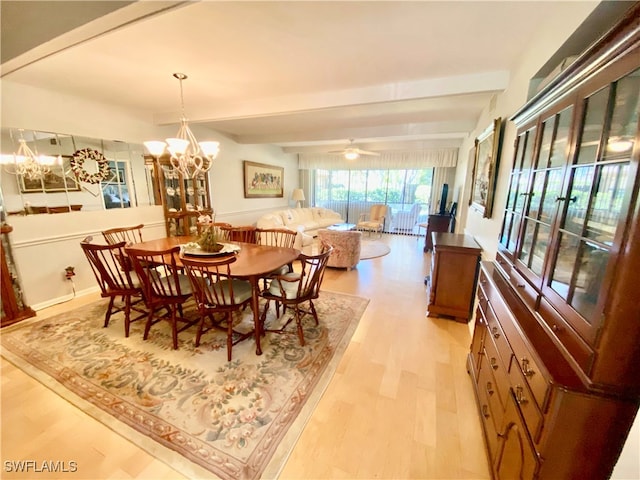 dining space featuring beamed ceiling, ceiling fan with notable chandelier, and light hardwood / wood-style flooring