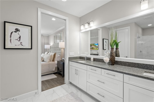 bathroom with wood-type flooring, vanity, crown molding, and a shower with shower door